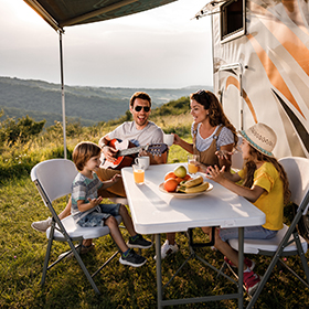 Family camping outside with an RV