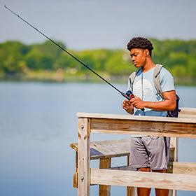 young man fishing from a dock