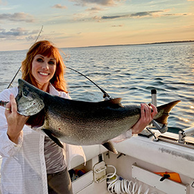 Woman on boat holding salmon