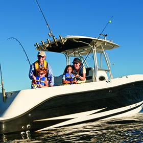 family fishing on a boat