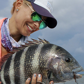 Woman holding fish after saltwater fishing