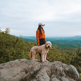 Young woman hiking with her dog