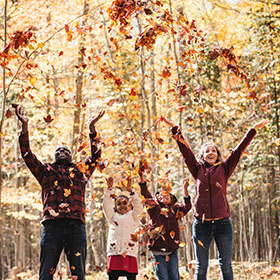 family playing with fall leaves