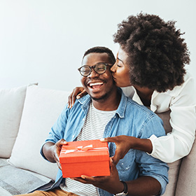 Woman gifting her partner a holiday gift