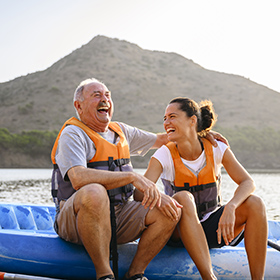 hispanic adult father and daughter in a kayak