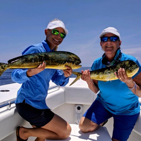 Two ladies on a boat showing their catch