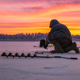 person using an ice auger for ice fishing