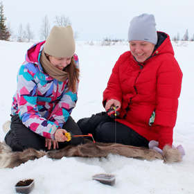 two ladies ice fishing