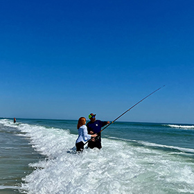 man and woman surf fishing 