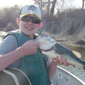 kid holding his catch after using live bait for bass