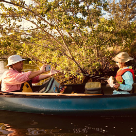 Dad and son on a kayak fishing, kid showing his catch