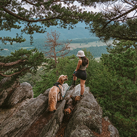 Young woman hiking with her dog