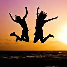 people jumping of happiness on a sunset