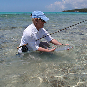 Woman holding fish after saltwater fishing