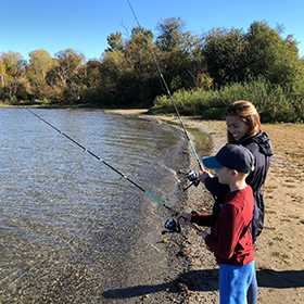 mom and son fishing in the shore