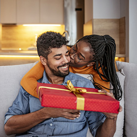 Woman giving her boyfriend a holiday gift
