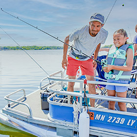 family on a pontoon boat fishing on a lake