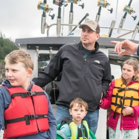 Father and kids fishing and boating in Alaska