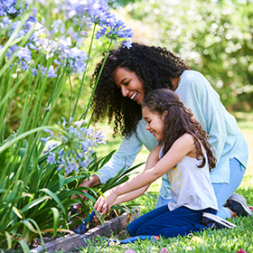 Mother and daughter tending a flower garden