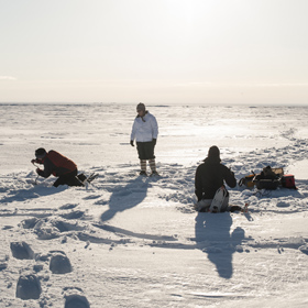 three friends ice fishing 